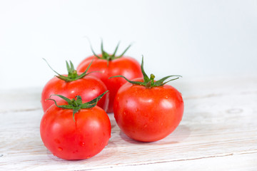 Harvest. Red tomatoes with a green stem. Space for your text.
