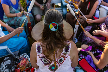 Sacred drums during spiritual singing. A high angle view of a woman wearing native headband and...