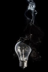 broken light bulb and smoke from a burning spiral on a black background