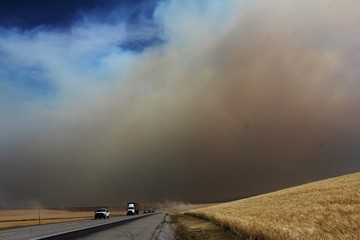 Smoke cloud chasing semi on road from Wild Fire