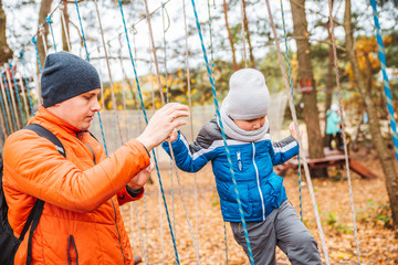 father with toddler kid son playing at playground autumn season