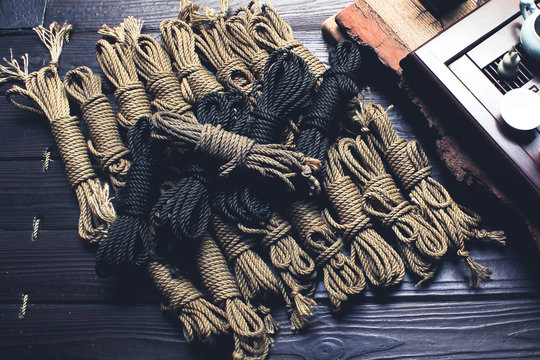 Ropes of ropes in different colors for a shibari with a tea set. Concept of BDSM.