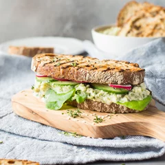 Papier Peint photo Lavable Snack Sandwich au houmous de haricots verts sur une planche de bois sur fond clair