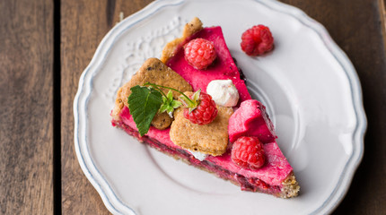 Raspberry tart with meringue on a wooden background