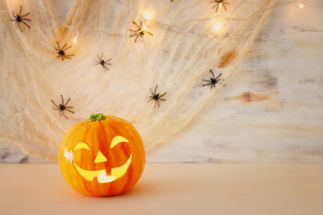 holidays halloween concept image. Pumpkin, spiders over wooden table