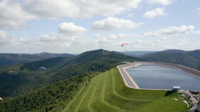 Two paragliders flying around pumped storage hydroelectricity on Gora Zar in Poland