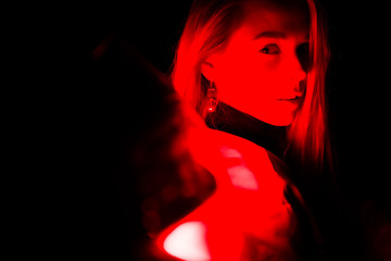 Woman laying on car covered with red light. 