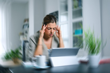 Sick dizzy young woman suffering headache while working on her laptop at home. - 293734604