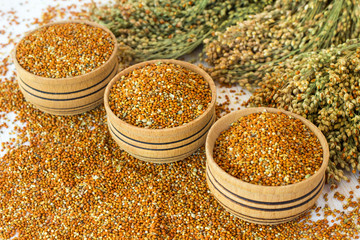 Grains of millet in a wooden a box. Twigs with millet.