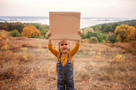 Young kids holding a poster over autumn nature background