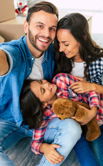 Our life is a gift. Family portrait of a man, his wife and their daughter who smiles and looks at...