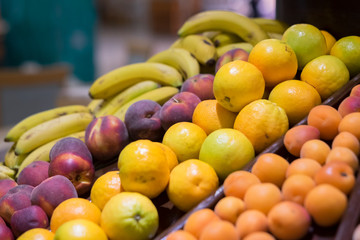 close up of some fruits like oranges, red peachs and bananas - supermarket of fruit - nobody at the picture