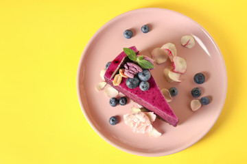Plate with tasty blueberry cake on color background