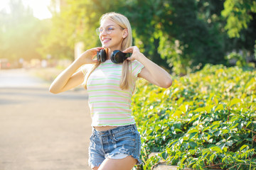 Beautiful young woman with headphones outdoors