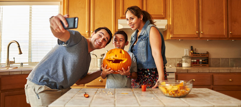 Family Taking Selfie With Jack-o-lantern For Halloween