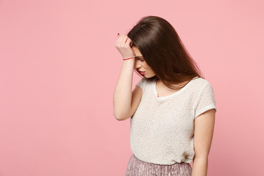 Exhausted young woman in casual light clothes posing isolated on pink background in studio. People sincere emotions lifestyle concept. Mock up copy space. Putting hand on head, keeping eyes closed.