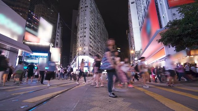 People and taxi cabs, double deck buses, trams crossing a very busy crossroads in the central district in rush hour. Hectic city, fast speed metropolis, time lapse. Traffic jam