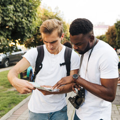 Intercultural friends reading map together