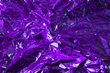 Creative photo background of violet crumpled foil with highlights and shadows