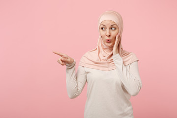 Arabian muslim girl in hijab light clothes posing isolated on pink background. People religious...