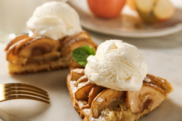 Piece of apple pie with ice cream on board, closeup