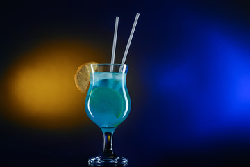 Glass of tasty summer cocktail on dark color background