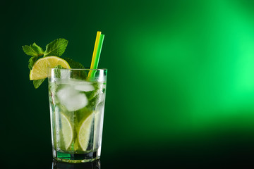 Glass of tasty cocktail on dark color background