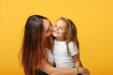 Woman in light clothes have fun with cute child baby girl 4-5 years old. Mommy little kid daughter isolated on yellow background studio portrait. Mother's Day love family parenthood childhood concept.