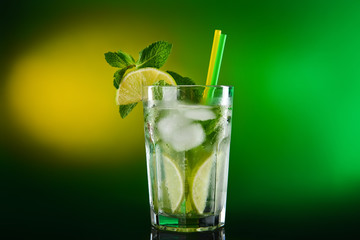 Glass of tasty cocktail on dark color background