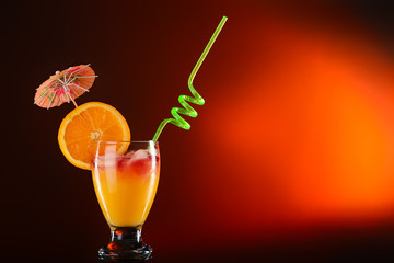 Glass of tasty cocktail on dark color background