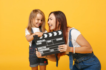 Woman in light clothes have fun with cute child baby girl 4-5 years old. Mommy little kid daughter isolated on yellow background studio portrait. Mother's Day love family parenthood childhood concept.