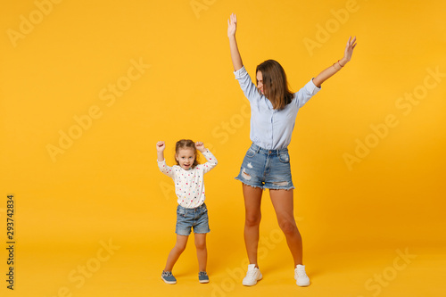 Woman in light clothes have fun with cute child baby girl 4-5 years old. Mommy little kid daughter isolated on yellow background studio portrait. Mother's Day love family parenthood childhood concept.