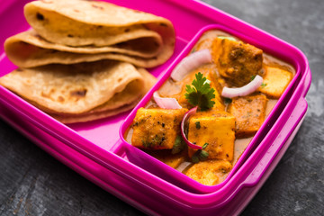 Paneer Butter Masala with Roti in lunch box or tiffin, selective focus