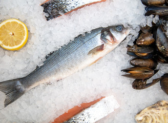 Fish with lemon in the ice on the counter