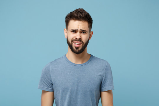 Young perplexed disgusted irritated man in casual clothes posing isolated on blue wall background, studio portrait. People sincere emotions lifestyle concept. Mock up copy space. Looking camera.