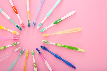 Many different tooth brushes on color background