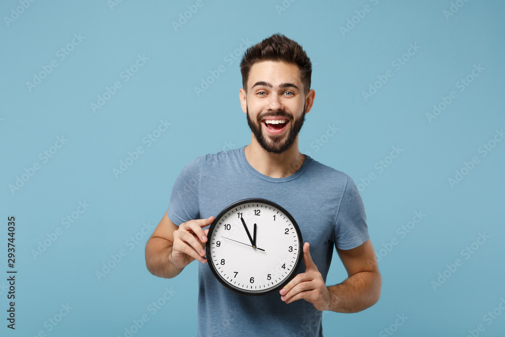 Wall mural young cheerful laughing man in casual clothes posing isolated on blue wall background, studio portra