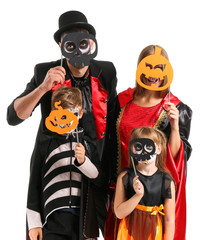 Family in Halloween costumes on white background