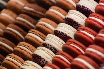 Colorful cakes macaron aka French macarons lie on the counter. Multi-colored macarons lie in rows.