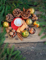 fir branches, Christmas sweets and coffee cup. Christmas decor on rustic wooden table background. Christmas and new year festive still life. top view. soft selective focus