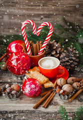 classic traditional winter festive composition with coffee cup, cookies, nuts, candy, cinnamon and christmas tree branches. Christmas decor on rustic table. Christmas and New Year Holiday. soft focus 