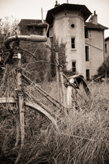 un vieux vélo abandonné devant une maison abandonnée