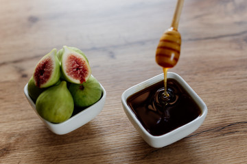Figs and honey in a white bowl