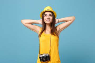 Traveler tourist woman in yellow summer casual clothes, hat with photo camera isolated on blue background. Female passenger traveling abroad to travel on weekends getaway. Air flight journey concept.