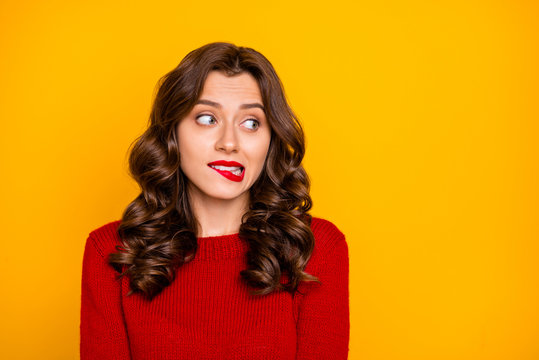 Photo of charming stylish curly wavy trendy cute attractive nice sweet pretty girlfriend biting her lips while watching something away isolated over yellow vibrant color background