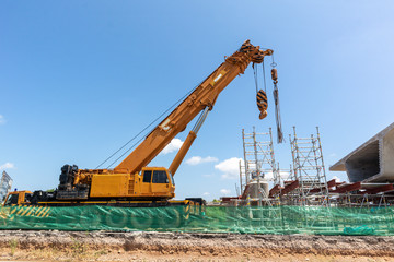 Fototapeta na wymiar Construction bridge or expressway equipment site structure. Mobile crane construction expressway on the blue sky background.