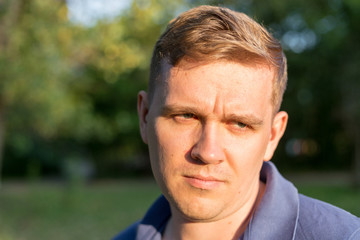 Fototapeta premium Person offended men. Portrait of a young guy on nature background, feelings and people reaction.