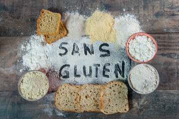 gluten-free (sans gluten) bread and flour on wooden background - obrazy, fototapety, plakaty