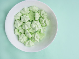mint merengues in white bowl on mint backdrop