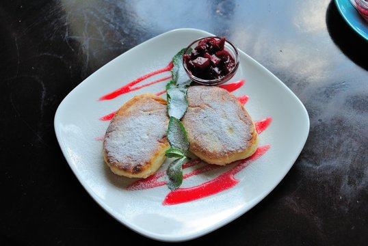 Russian syrniki (tvorozhniki) served with Russian jam called varenye